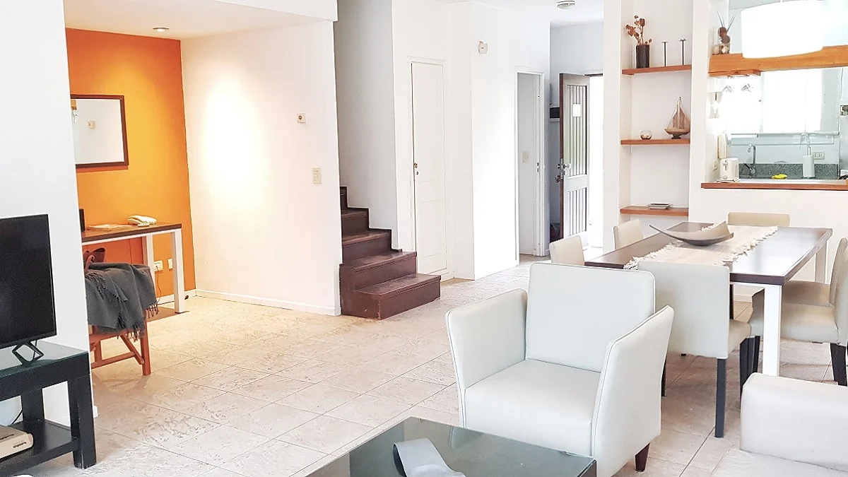 Escalera al 2do piso y zona comedor y cocina del depto 1A de Terrazas de Cariló